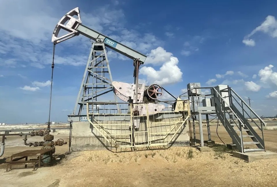 Oil well pumpjack with the number 3332 on the walking beam; next to it, a control cabinet and a ladder to the inspection platform.